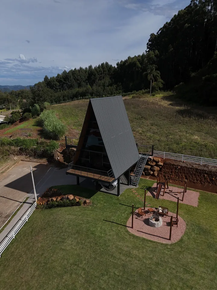 A cabana vista do alto, com o pátio gramado, o firepit e o playground